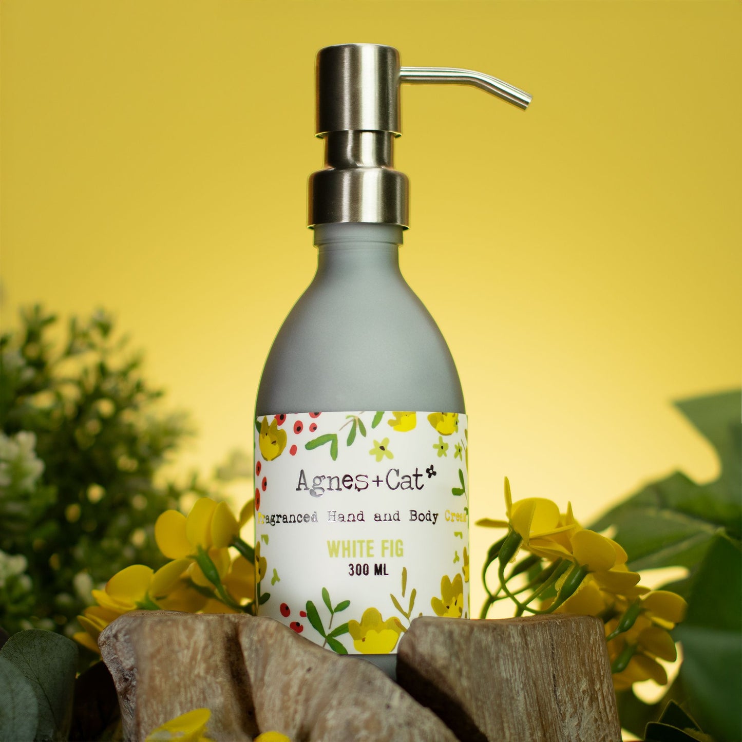 Hand soap bottle with pump labeled 'Agnes + Cat' on a yellow background with flowers.