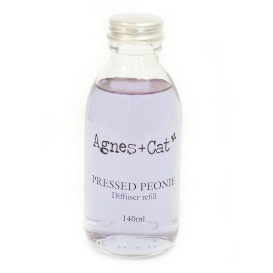Glass diffuser refill bottle labeled 'Agnes + Cat Pressed Peony' on a white background