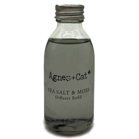 Glass diffuser refill bottle labeled 'Agnes + Cat Sea Salt & Moss' on a white background