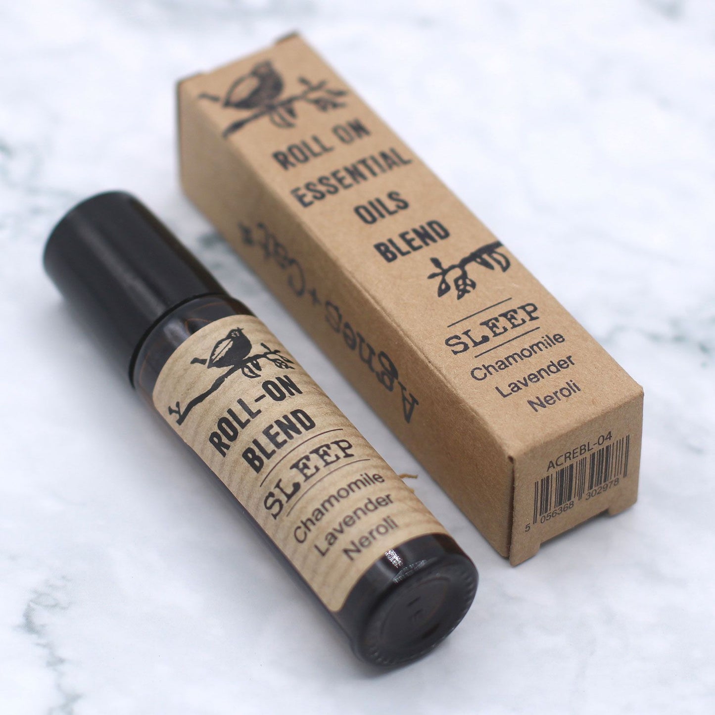 Roll-on essential oils blend with packaging on a marble surface