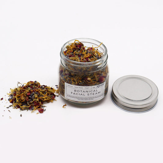 Jar of botanical facial steam with lid on a white background