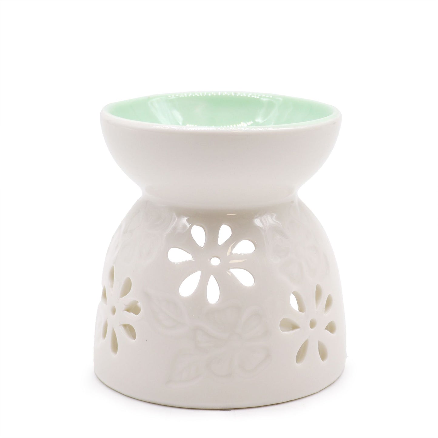 White ceramic oil burner with floral cutouts on a white background