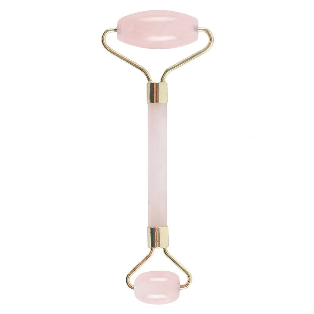 Pink and gold facial roller on a white background