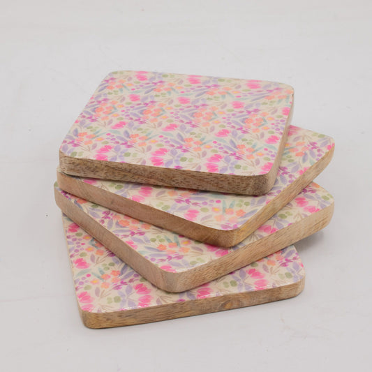 Set of four floral patterned coasters on a light gray background