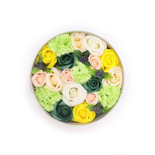 Round flower arrangement with green, yellow, and pink flowers on a white background