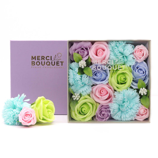 Pastel-colored flowers in a box with 'Merci Bouquet' branding.