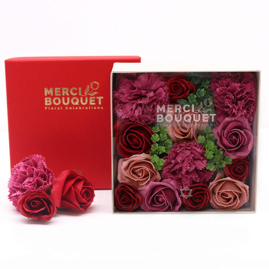 Box of Merci Bouquet flowers with a red card in the background