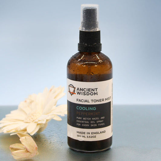 Facial toner mist bottle labeled 'Ancient Wisdom' with a flower on a reflective surface.
