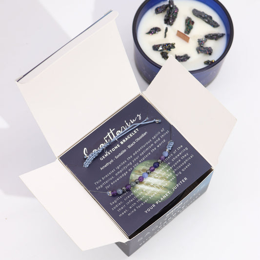 Zodiac Crystal Candle Sagittarius with Gemstone Bracelet boxed is beautifully presented in a midnight blue glass jar adorned with silver-embossed star sign constellations.