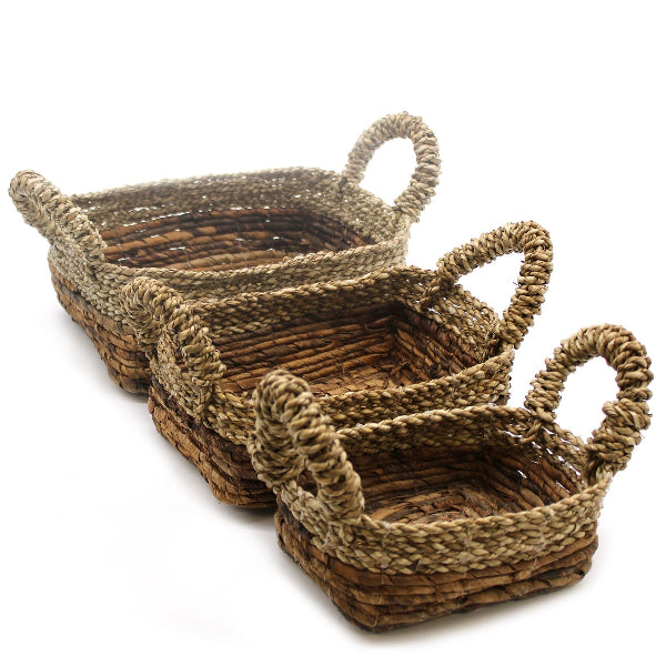 Set of three woven baskets with handles on a white background