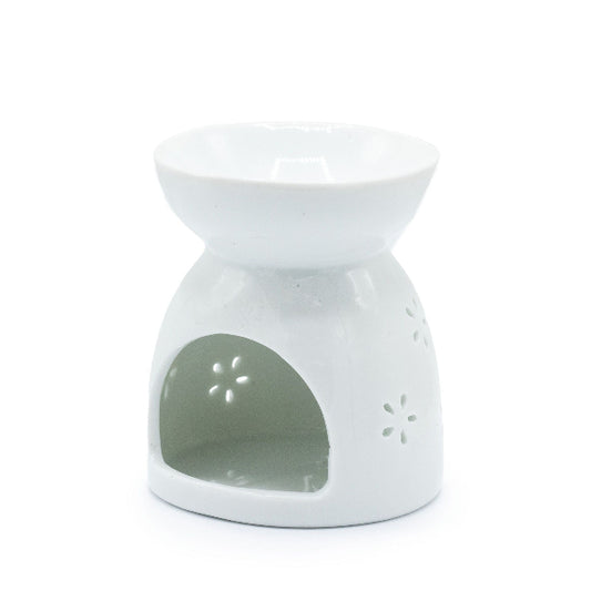 White ceramic oil burner with floral design on a white background