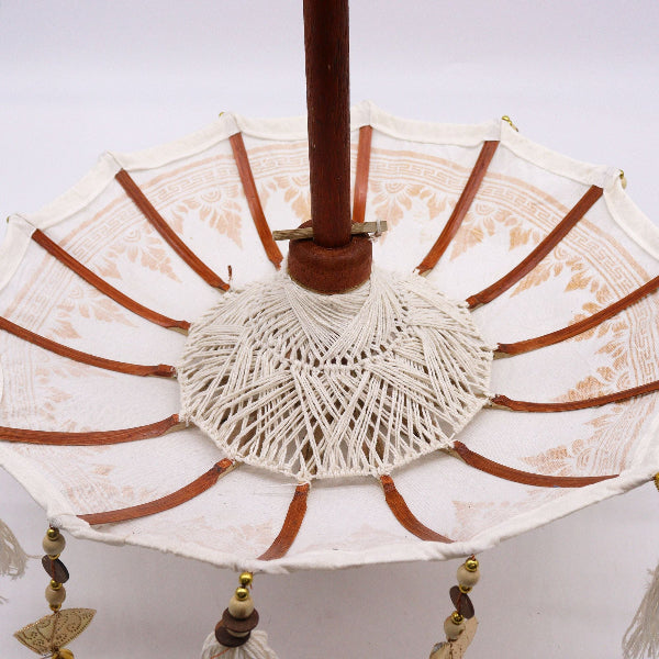 Close-up of a decorative umbrella with wooden handle and white canopy on a white background