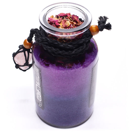 Purple glass jar with a lid containing dried flowers on a white background