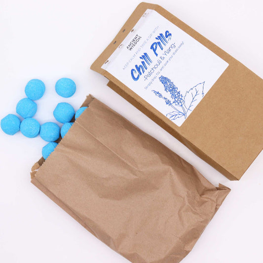 Blue balls in an open brown paper bag with a branded label on a white background