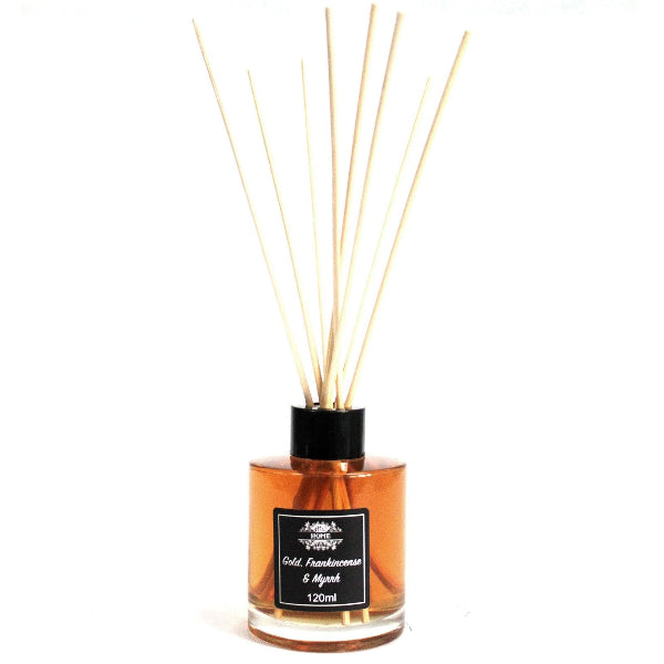 Reed diffuser with wooden sticks in an amber glass bottle on a white background