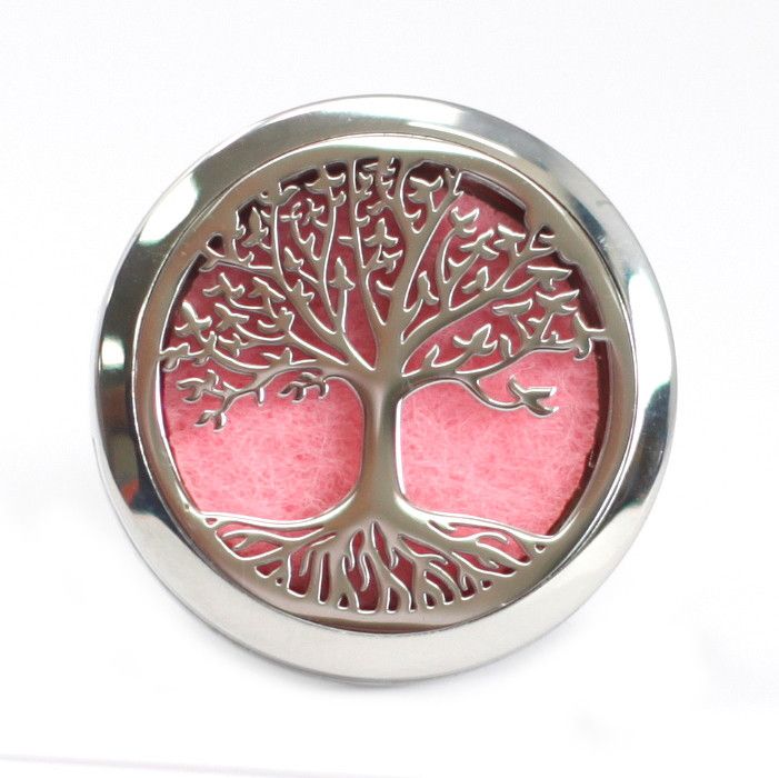 Decorative metal plate with tree of life design on a pink background