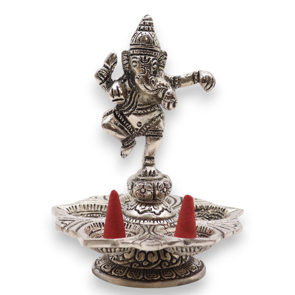 Decorative metal incense holder with red cones on a white background