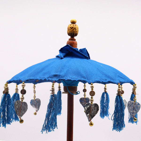 Decorative blue parasol with tassels and heart-shaped decorations on a white background