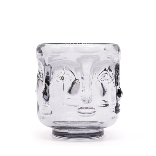 Clear glass tumbler with face design on a white background