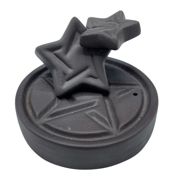 Black decorative object with star designs on a white background