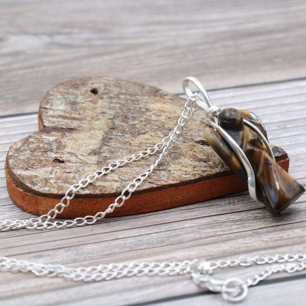 Necklace with a tiger's eye stone on a wooden heart-shaped block