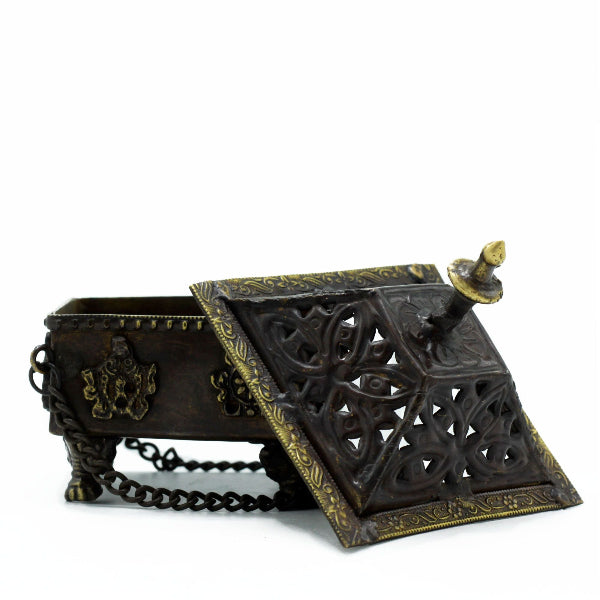 Decorative metal box with intricate designs and a chain on a white background