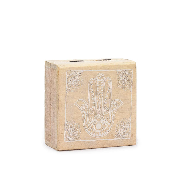 Wooden block with Hamsa hand design on a white background