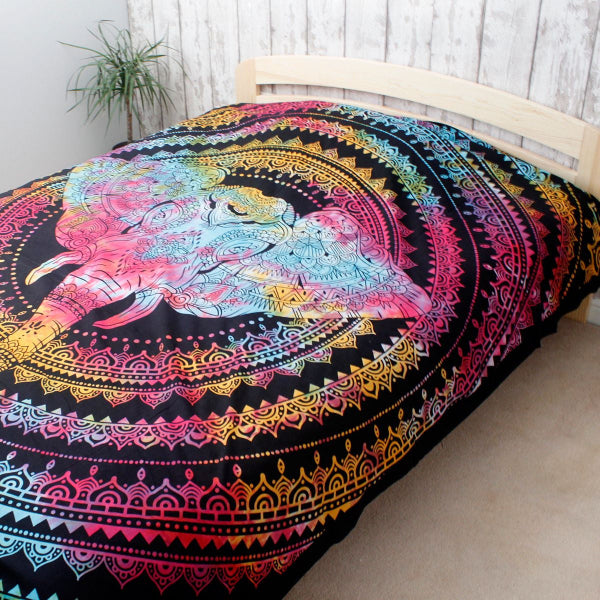 Colorful tapestry with a lion design on a bed in a room.