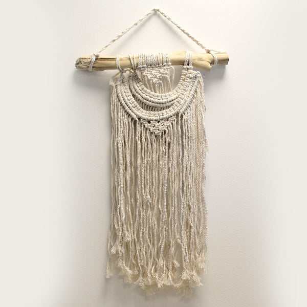 Macrame wall hanging with wooden frame on a white background