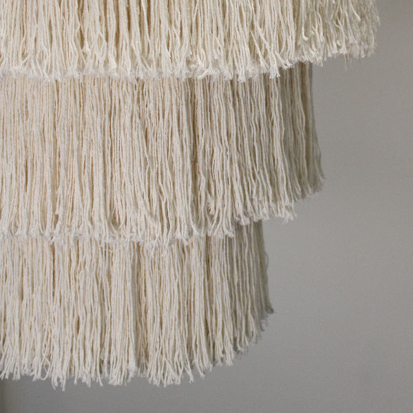 Close-up of a textured fabric with fringes on a plain background