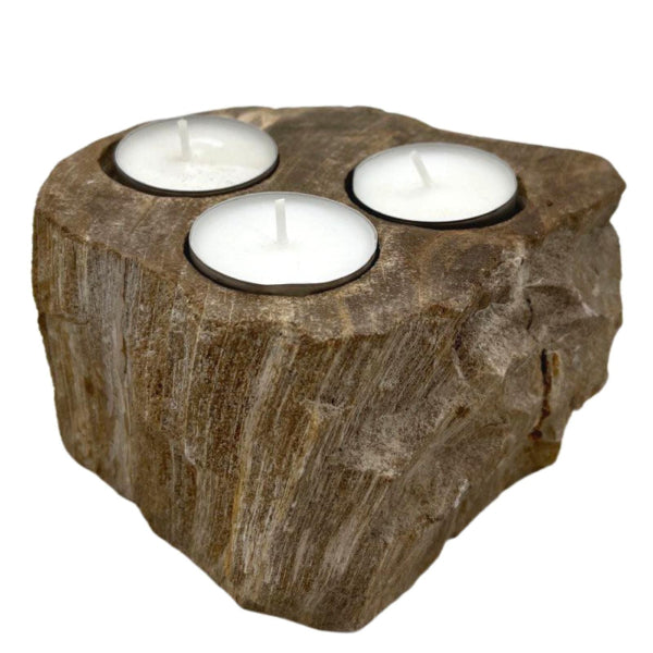 Rustic wooden candle holder with three white candles on a white background