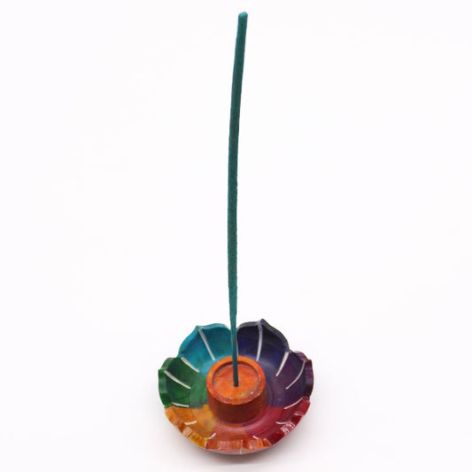 Colorful incense holder with a single green incense stick on a white background