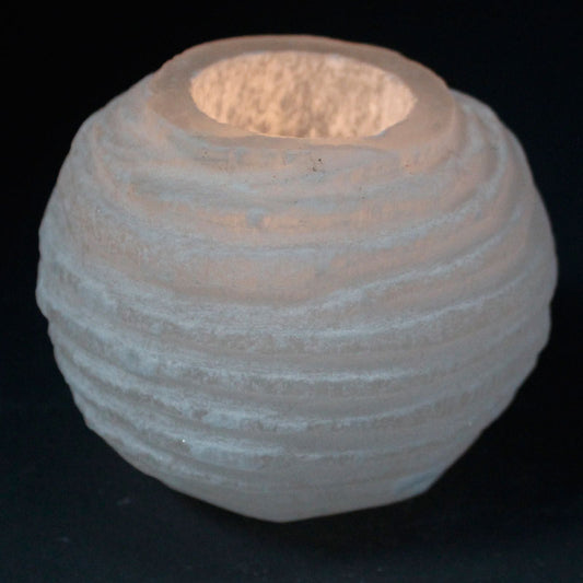 Textured ceramic candle holder on a black background