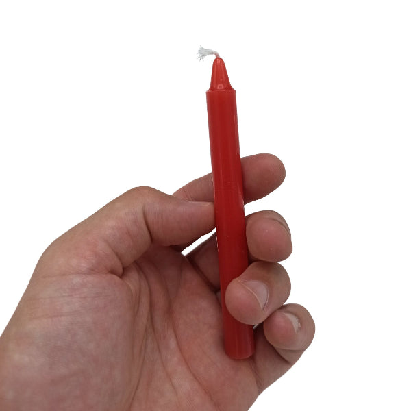 Hand holding a red candle against a white background