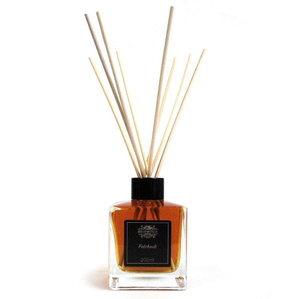 Reed diffuser with wooden sticks in a clear bottle on a white background