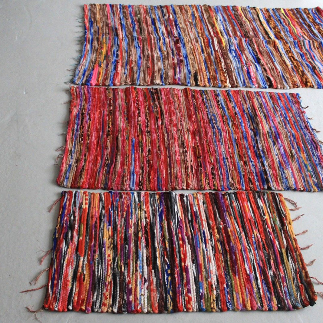 Set of colorful woven rugs on a plain background