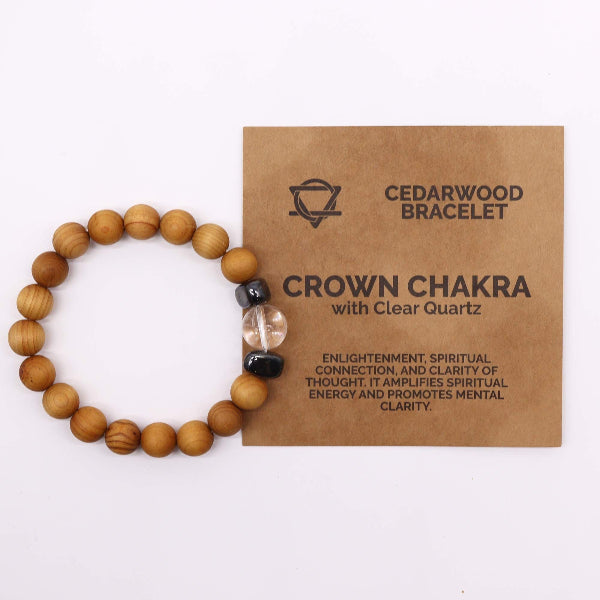 Wooden bracelet with clear quartz bead on a brown card labeled 'Cedarwood Bracelet Crown Chakra' on a white background