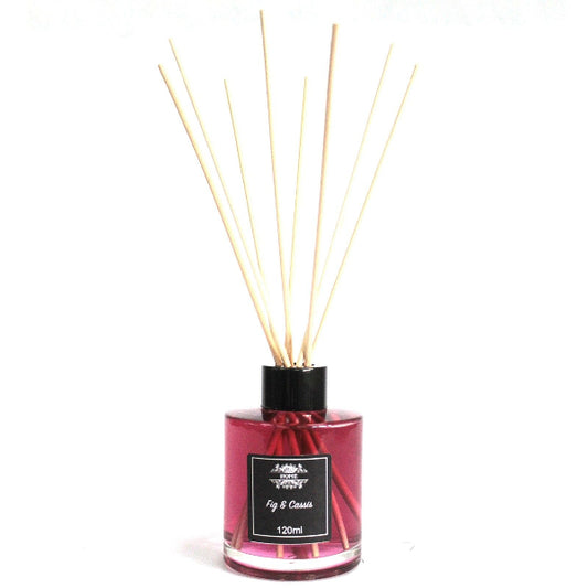 Reed diffuser with wooden sticks in a pink bottle on a white background