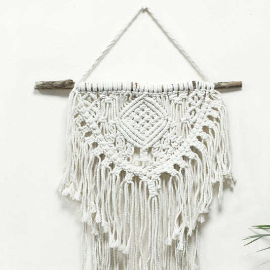 Macrame wall hanging with white yarn and wooden sticks on a white background