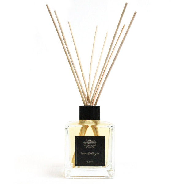 Reed diffuser with wooden sticks and a black cap on a white background