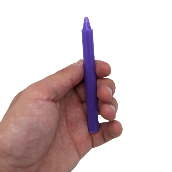 Hand holding a purple marker against a white background