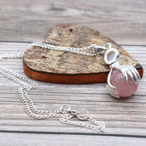 Necklace with a pink pendant on a wooden surface