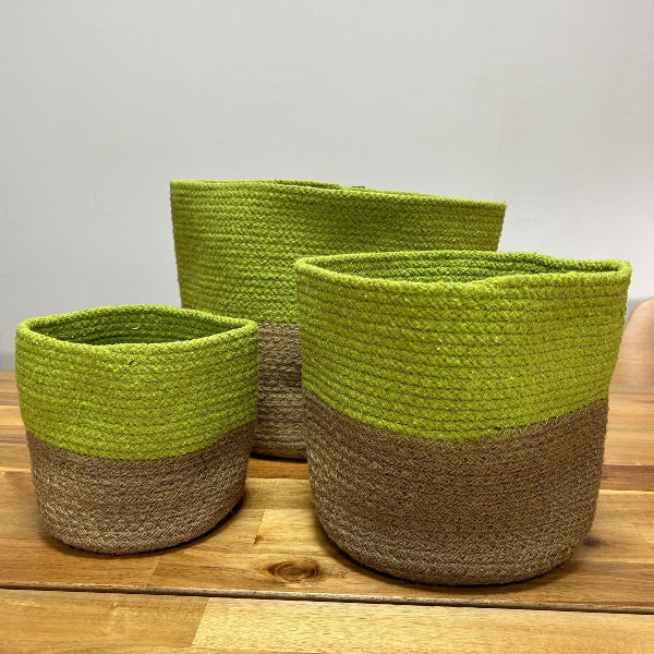 Three green and brown woven baskets on a wooden surface