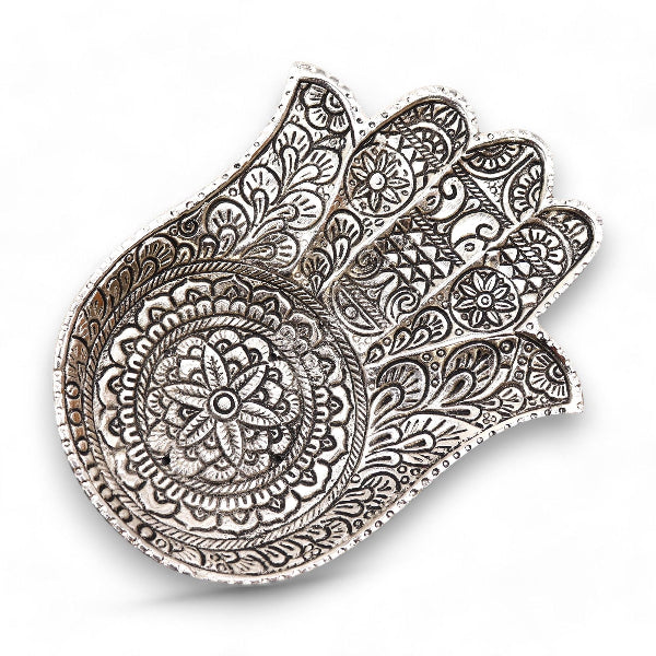 Decorative metal hamsa with intricate patterns on a white background