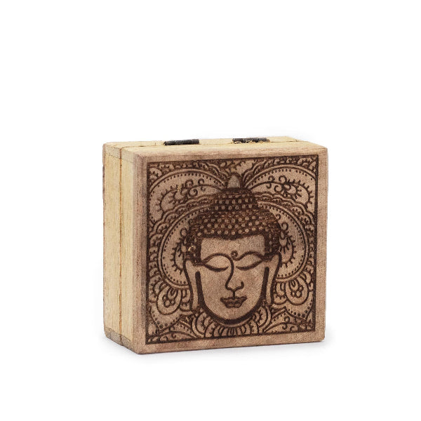 Wooden block with Buddha face design on a white background
