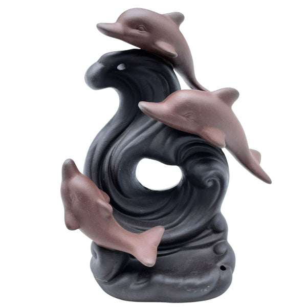 Decorative sculpture of three dolphins on a wave with a white background