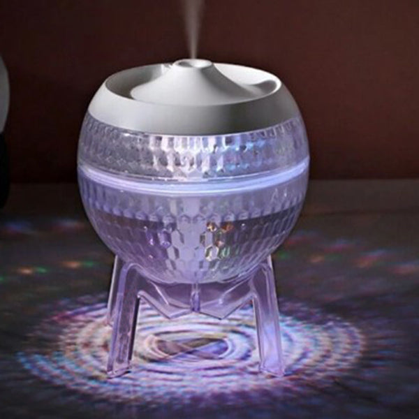 Decorative lamp with crystal-like design and colorful light projection on a dark surface.