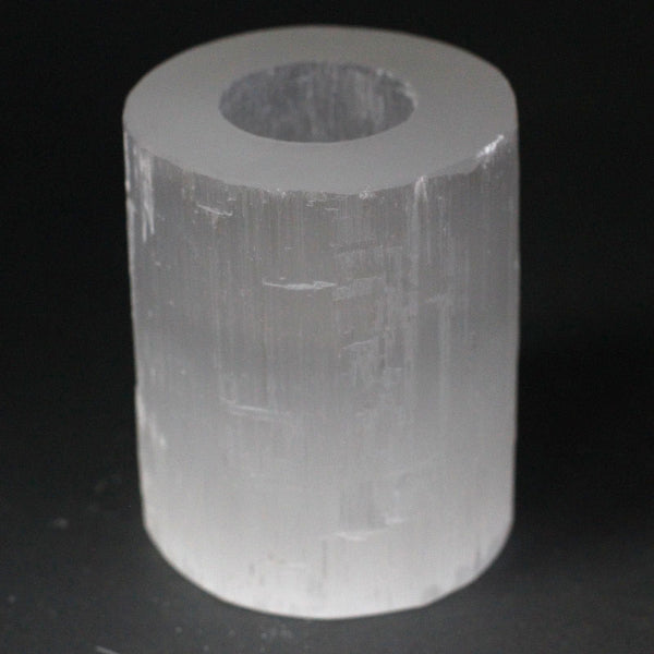 Clear cylindrical crystal on a black background