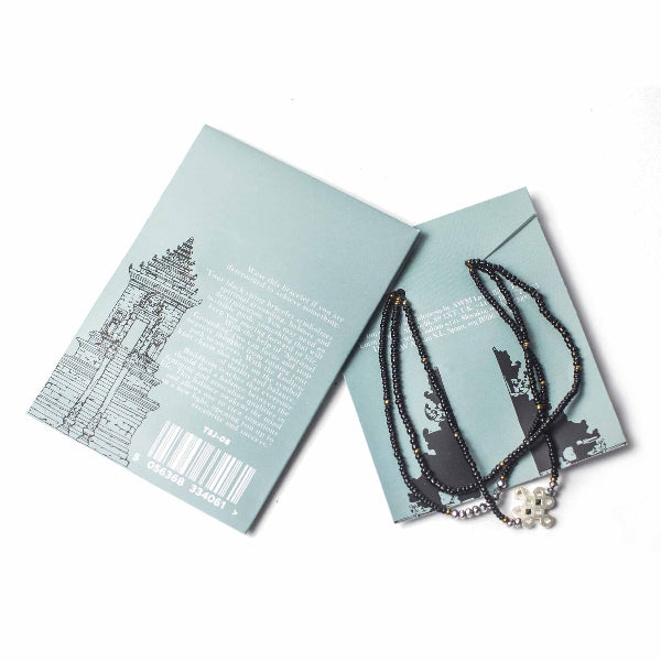 Necklace with skull pendant on a card with text and graphics