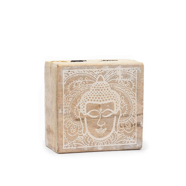 Wooden block with Buddha face design on a white background